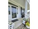 Inviting front porch with flowers, a bench, and natural light streaming through the glass door at 1002 Dogwood Bloom Ln, Knightdale, NC 27545
