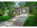Charming home with a spacious driveway, stone facade, manicured lawn, and attached garage at 10113 San Remo Pl, Wake Forest, NC 27587