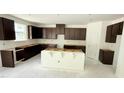 A bright kitchen features dark wood cabinets and a large central island ready for countertops and appliances at 102 Gobbler Dr, Smithfield, NC 27577