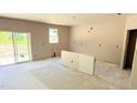 Spacious kitchen featuring sliding glass door and a window to provide natural light in an unfinished space at 102 Gobbler Dr, Smithfield, NC 27577