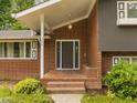 Home featuring a brick entrance, a covered front porch, and manicured shrubs at 1024 Chalmers St, Durham, NC 27707