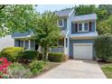 Two-story home showcasing its blue exterior, white trim, and attached one-car garage at 103 Trent Woods Way, Cary, NC 27519