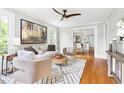 Bright living room featuring hardwood floors, stylish decor, and an open layout with views to the dining area at 107 E Hammond St, Durham, NC 27704