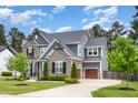 Attractive two-story home showcasing stone and gray siding, a well-kept lawn, a driveway, and a two-car garage at 1112 Valley Rose Way, Durham, NC 27712