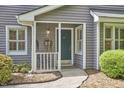 Inviting entryway with a covered porch, hanging flowers, and a welcoming front door at 115 Standish Dr, Chapel Hill, NC 27517
