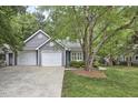 The house features a two-car garage with a well-maintained lawn and mature trees in the front at 115 Standish Dr, Chapel Hill, NC 27517