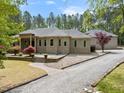 Expansive brick home featuring a gravel driveway, lush lawn, and inviting landscape design at 120 Wood Lake Dr, Fuquay Varina, NC 27526