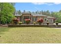 Inviting brick home featuring manicured landscaping and blooming bushes enhancing curb appeal at 120 Wood Lake Dr, Fuquay Varina, NC 27526