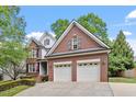 Charming brick home featuring a two-car garage and well-maintained landscaping at 121 Cobblepoint Way, Holly Springs, NC 27540