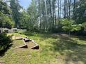 Picturesque backyard with lush green grass and mature trees offering ample shade and privacy at 125 Occidental Dr, Holly Springs, NC 27540