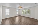 Light-filled bedroom featuring large windows, wood-look flooring, and neutral paint at 125 Occidental Dr, Holly Springs, NC 27540