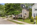 Two-story home with beige siding and black shutters, surrounded by landscaped yard and trees at 125 Occidental Dr, Holly Springs, NC 27540