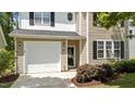 Two-story home featuring beige siding, black shutters, an attached garage, and landscaped front yard at 125 Occidental Dr, Holly Springs, NC 27540