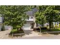 Two-story home with beige siding, black shutters, garage, manicured landscaping, and mature shade trees at 125 Occidental Dr, Holly Springs, NC 27540