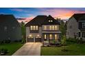 Charming two-story home with brick facade, covered front porch, and manicured lawn at dusk at 1632 Ferntree Ct, Morrisville, NC 27560