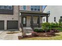 Inviting front porch with covered entry, brick columns, and landscaped garden at 1632 Ferntree Ct, Morrisville, NC 27560