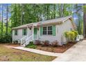Inviting home exterior with white siding, green shutters, and well-manicured landscaping at 1703 Cranston Road Rd, Garner, NC 27529