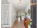 Inviting entryway with hardwood floors, decorative console table, and view to the kitchen at 1824 Amberly Ledge Way, Cary, NC 27519