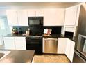 Modern kitchen featuring sleek black countertops, stainless steel appliances and pristine white cabinetry at 1846 Forest Wood Rd, Rocky Mount, NC 27804