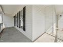 Wide angle view of the covered front porch with vinyl siding, black shutters, and concrete floor at 2028 Ruddy Rd, Raleigh, NC 27616
