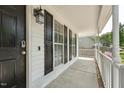 View of the front porch with black door and shutters, digital lock, and outdoor light fixture at 2028 Ruddy Rd, Raleigh, NC 27616