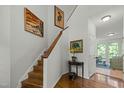 Bright foyer with a wooden staircase and stylish decor, leading to the upper level of the home at 205 Glenview Pl, Chapel Hill, NC 27514