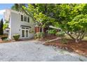 Two-story home with modern design, gravel driveway, and lush landscaping at 209 N Occoneechee St, Hillsborough, NC 27278