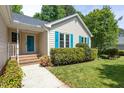 Home's exterior showcasing a blue front door, walkway, and manicured shrubbery at 210 Needle Park Dr, Cary, NC 27513