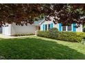 Landscaped front yard with vibrant green grass, mature trees, and blue shuttered home at 210 Needle Park Dr, Cary, NC 27513