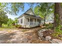 This home has a quaint porch and mature trees in the yard at 2102 Courtland Dr, Sanford, NC 27330