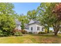 Charming home surrounded by lush greenery, trees, and blooming rose bushes at 2102 Courtland Dr, Sanford, NC 27330
