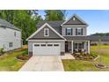 Charming two-story home boasts a well-maintained lawn, inviting porch, and a convenient two-car garage at 2215 Montebell View Dr, Fuquay Varina, NC 27526