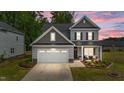 Charming two-story home with a well-manicured lawn, inviting front porch, and a convenient two-car garage at 2215 Montebell View Dr, Fuquay Varina, NC 27526