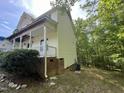 Home side showing exterior siding, brick foundation, AC Unit, and a lush treed yard undergoing renovations at 249 Finley Ct, Clayton, NC 27520