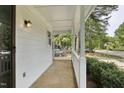 Side view of the front porch with white columns and stone flooring that offers curb appeal at 2611 Sawmill Rd, Raleigh, NC 27613