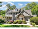 Attractive two-story home featuring a stone facade, covered porch, and lush landscaping on a sunny day at 2821 Penfold Ln, Wake Forest, NC 27587
