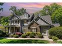 Attractive two-story home featuring a stone facade, covered porch, and lush landscaping on a sunny day at 2821 Penfold Ln, Wake Forest, NC 27587