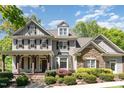 Charming two-story home with a stone facade, covered porch, and manicured landscaping under blue sky at 2821 Penfold Ln, Wake Forest, NC 27587