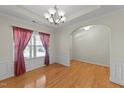 Bright dining room featuring hardwood floors, elegant chandelier, and large window with stylish curtains at 3212 Imperial Oaks Dr, Raleigh, NC 27614