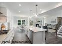 Open-concept kitchen with white cabinets, stainless steel appliances, and a view of the living room and dining area at 3621 Bailey Lake Dr, Fuquay Varina, NC 27526