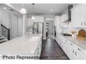 Modern kitchen features white cabinets, stainless steel appliances, a large center island, and hardwood floors at 3621 Bailey Lake Dr, Fuquay Varina, NC 27526