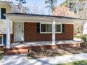 Inviting covered porch with brick accents and white columns, showcasing the house number at 3818 Hillgrand Dr, Durham, NC 27705