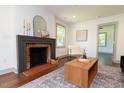 Bright living room showcasing a charming fireplace with brick surround, hardwood floors and neutral tones at 408 E Maynard Ave, Durham, NC 27704
