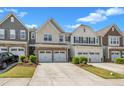 Attractive townhomes featuring two-car garages and manicured front landscaping under a sunny sky at 4137 Lofty Ridge Pl, Morrisville, NC 27560