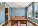 Formal dining room with a large table, modern light fixture, and large sunlit windows at 4405 Aubaun Way, Knightdale, NC 27545