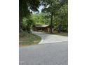Charming cabin nestled amongst tall trees with a patterned driveway leading to the home at 5601 Plum Nearly Ct, Raleigh, NC 27610