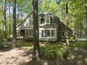 Lovely exterior view of a two-story home with large windows and dormers nestled among mature trees at 6000 Canadero Dr, Raleigh, NC 27612