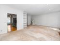 Open-concept living space with built-in shelving and easy access to kitchen and staircase at 6000 Tenter Banks Sq, Raleigh, NC 27609