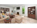Inviting living room featuring a fireplace, built-in bookshelves, and large windows for ample natural light at 6000 Tenter Banks Sq, Raleigh, NC 27609