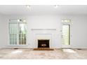 Bright living area with a white-painted fireplace, window, and door at 6000 Tenter Banks Sq, Raleigh, NC 27609